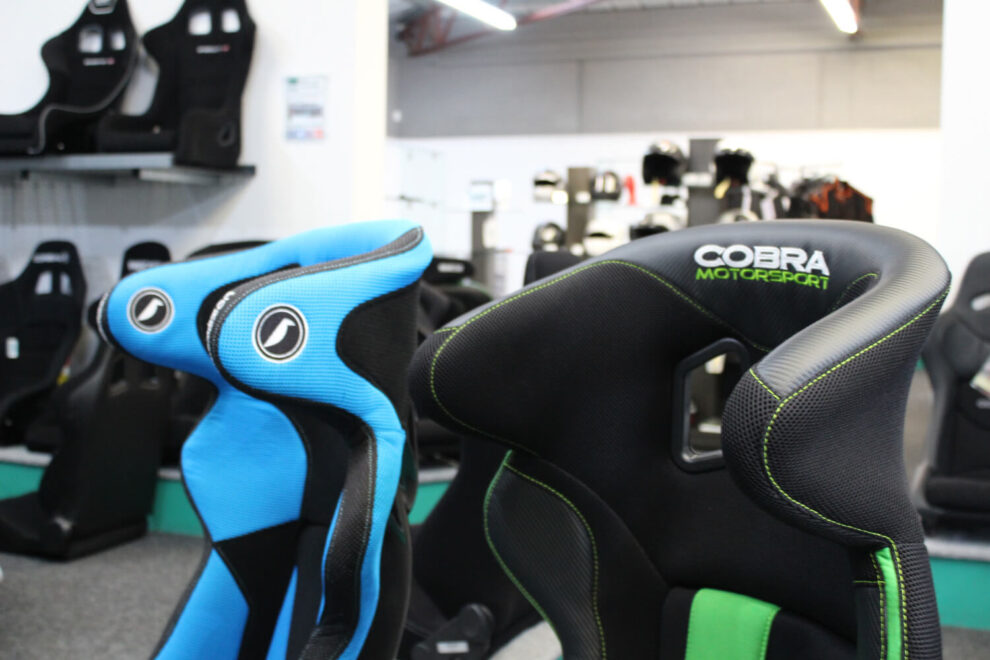 Close view of the head restraints on the blue Corbeau Revenge and the black Cobra Sebring with its Cobra Motorsport logo