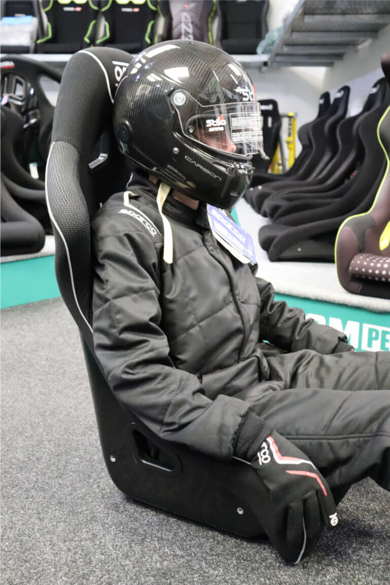 The same driver sat in the OMP WRC-R XL, with the wider shell leaving daylight either side of his shoulders