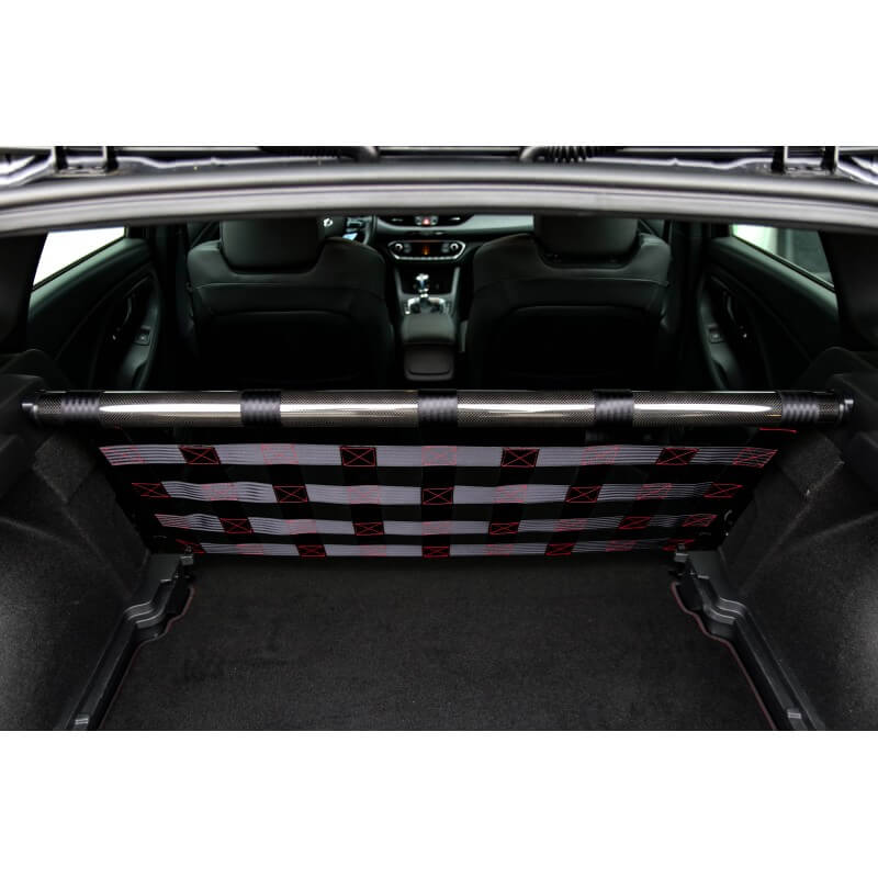 View through the open tailgate of a Hyundai i30 N with a carbon strut bar and grey and red webbing net, the front seats and dashboard beyond