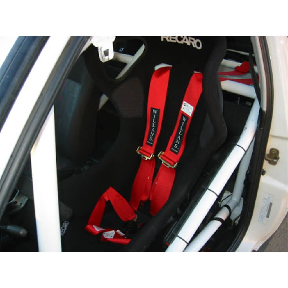 A red Willans harness on a black Recaro bucket seat in a car with a white roll cage