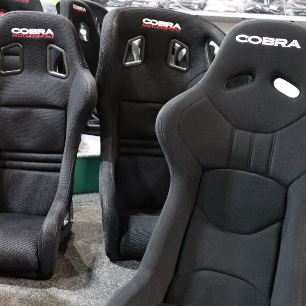 Black Cobra bucket seats in the showroom, with two Cobra Motorsport seats behind and a Cobra seat in the foreground