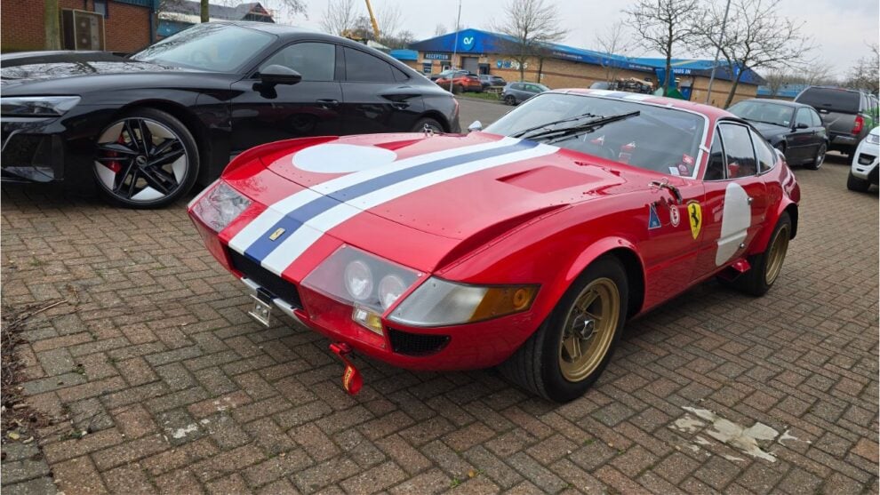 A red Ferrari Daytona with a white and blue stripe parked outside the GSM Performance unit
