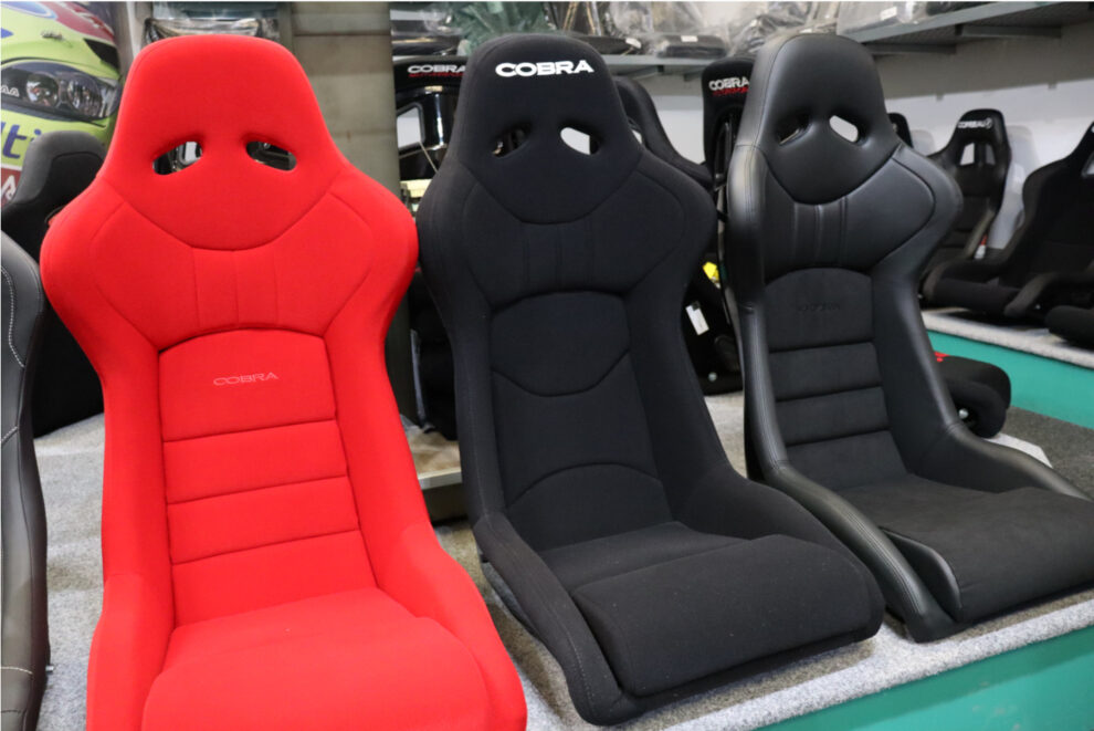 A red Cobra Nogaro Club Sport Ebisu Edition, a black velour Nogaro Club Sport and a black Nogaro Circuit side by side on the showroom display