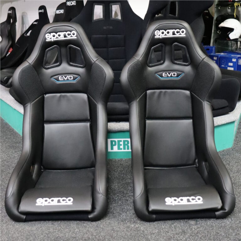 Two black Sparco Evo bucket seats with the Sparco logo and EVO badge side by side on our showroom floor