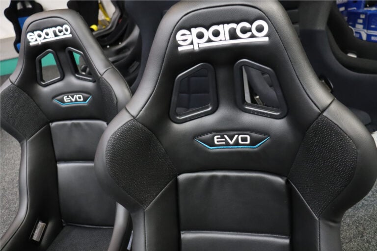 Close up of the upper back and headrest of a black Sparco Evo bucket seat in our showroom