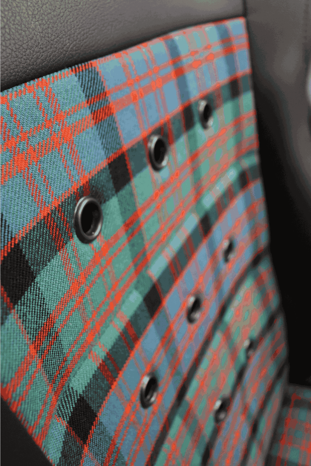 Close-up of the tartan centre panel and black eyelets on a Cobra Monaco 40th Edition seat