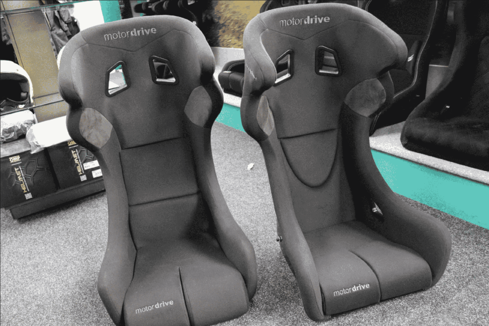 Two Motordrive Race FIA bucket seats side by side showing the integrated side head protection wings