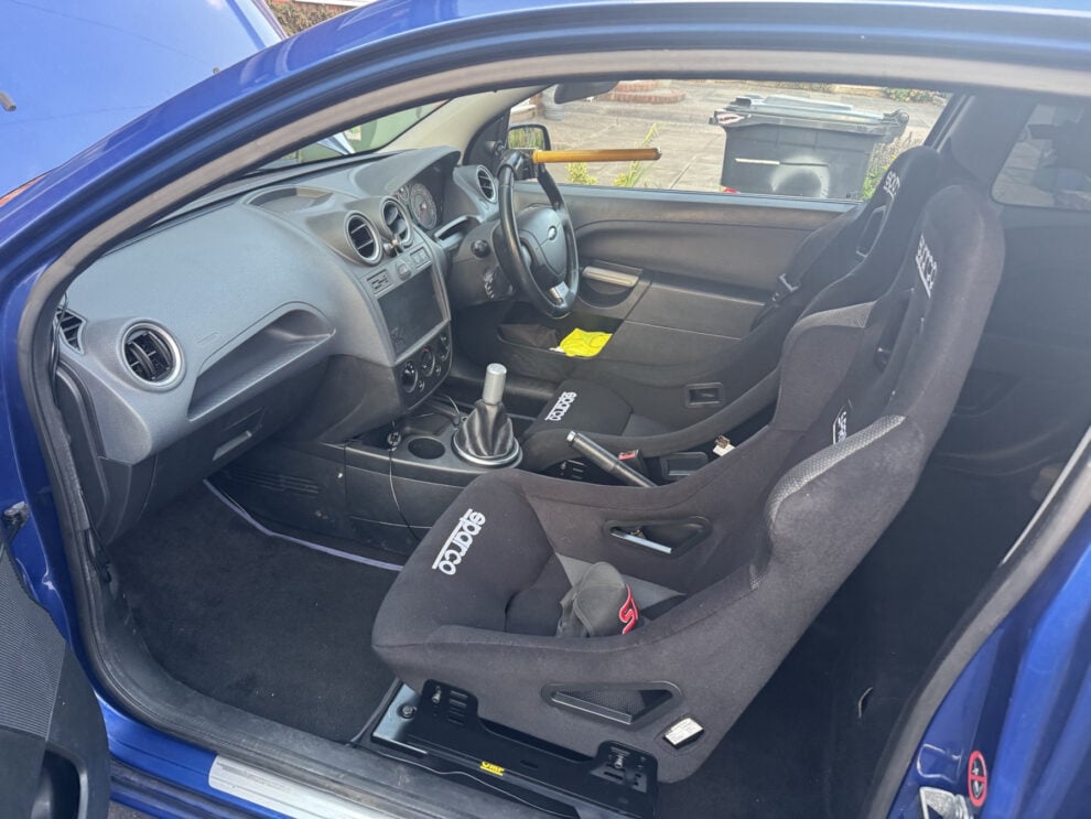 Interior of a blue Ford Fiesta Mk5 with a Sparco Sprint FIA bucket seat fitted on the passenger side on Endurance Motorsport side mounts and an OMP subframe, photographed by the owner