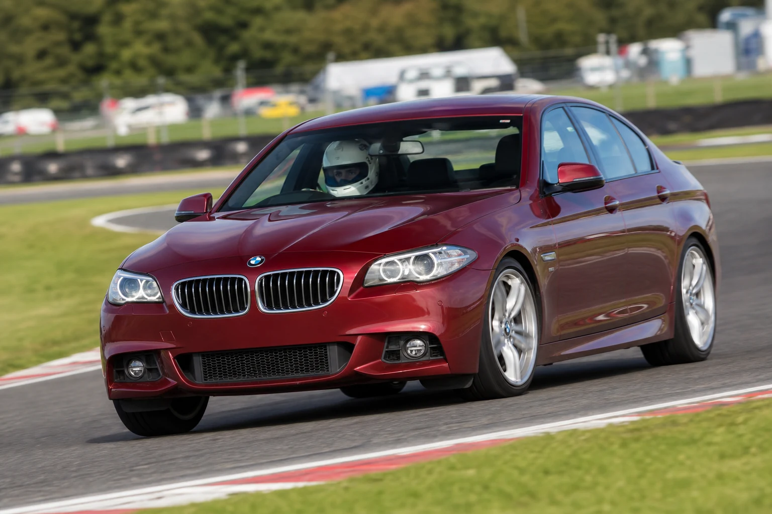 BMW 5 Series F10 on track with a helmeted driver
