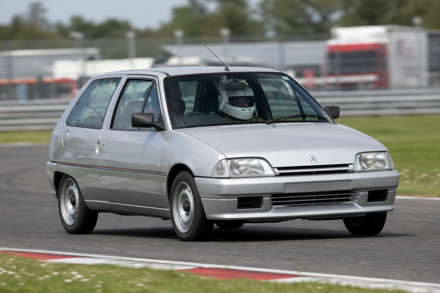 Citroen AX on track with a helmeted driver