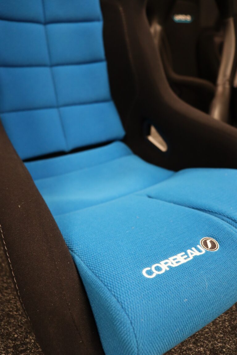 Close view of a blue fabric Corbeau bucket seat cushion showing the textured grippy weave