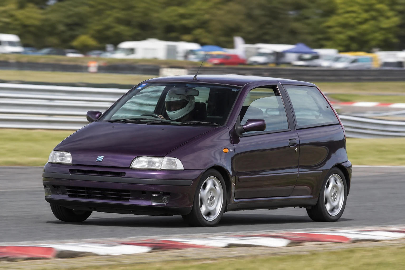 Fiat Punto Mk1 on track with a helmeted driver