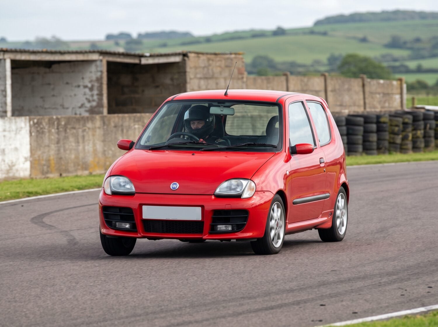 Red Fiat Seicento Sporting cornering on a British club racing circuit