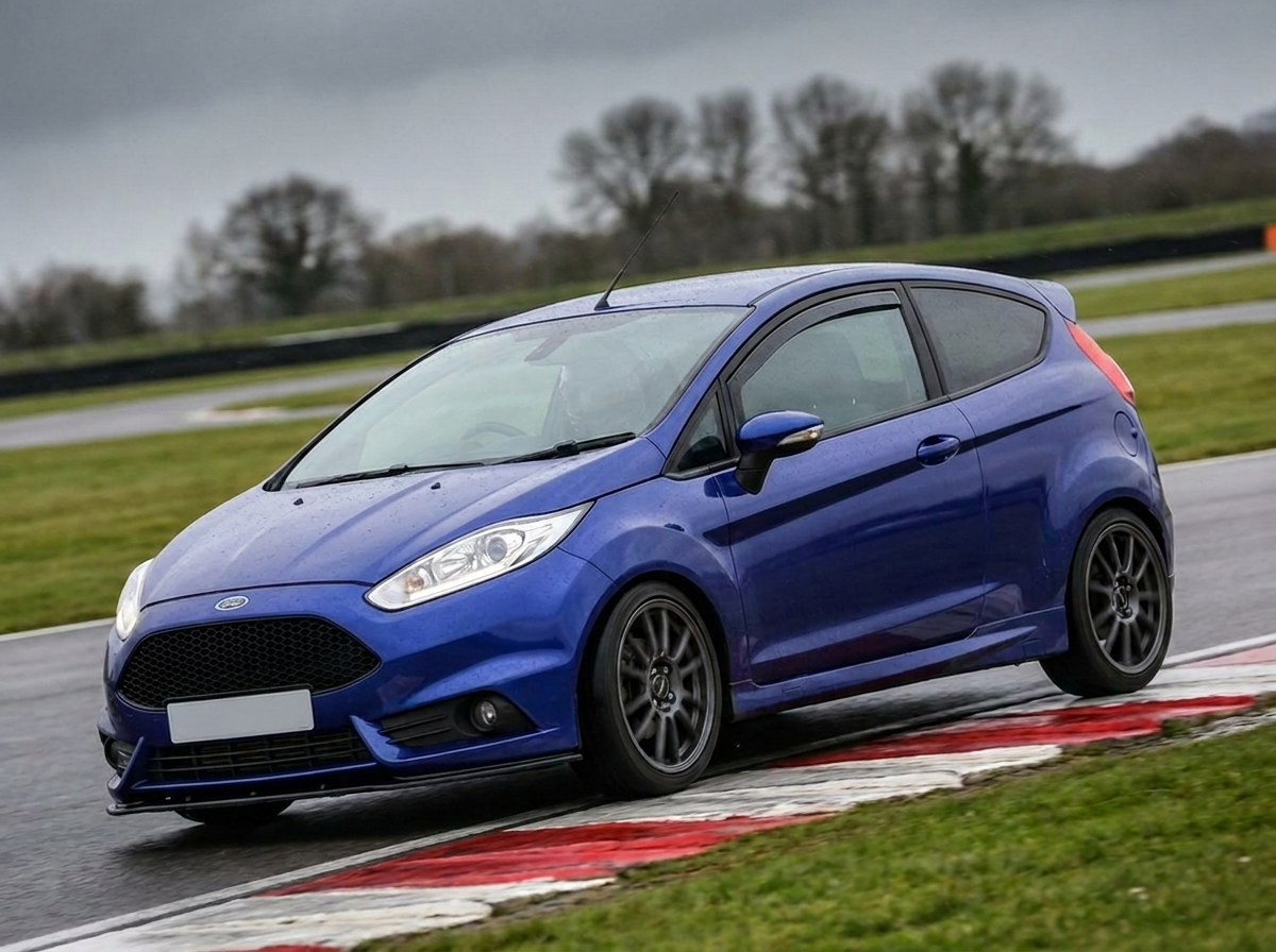 Blue Ford Fiesta ST180 Mk7 cornering on a British race circuit