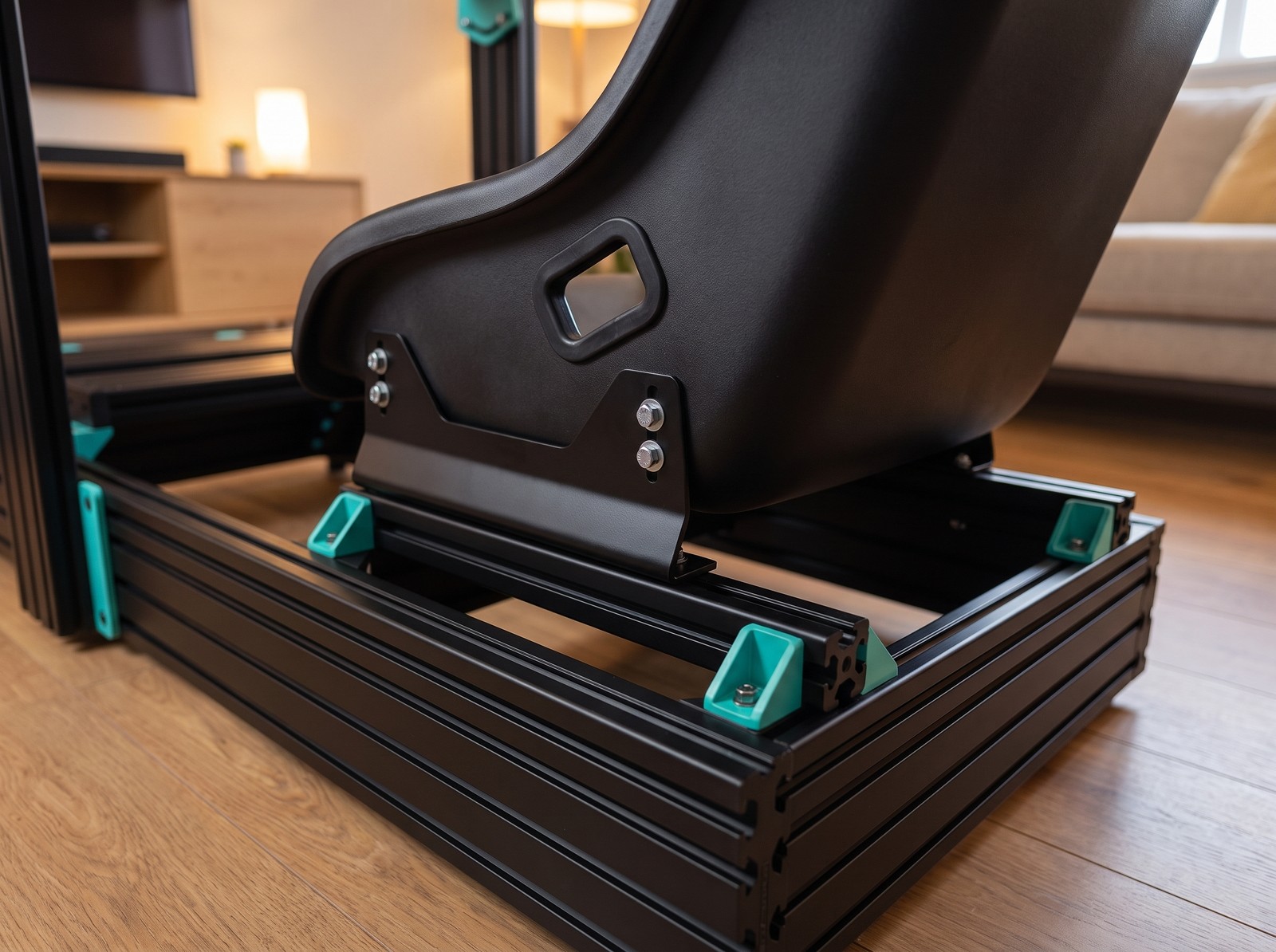 Plain black bucket seat on steel side mount brackets bolted to the black profile rails of a GT Omega PRIME style rig with teal gussets