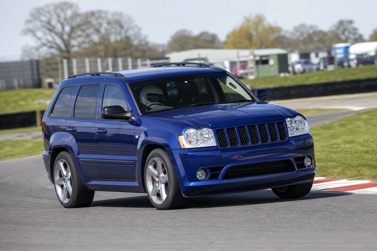 Jeep Grand Cherokee 3rd Gen on track with a helmeted driver