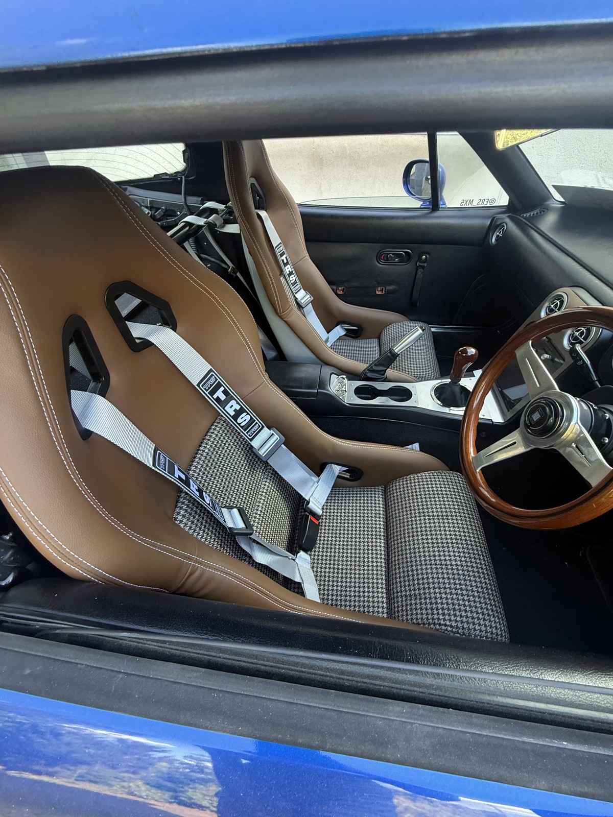 Tan and houndstooth Mirco bucket seat on the driver side of a Mk1 MX-5
