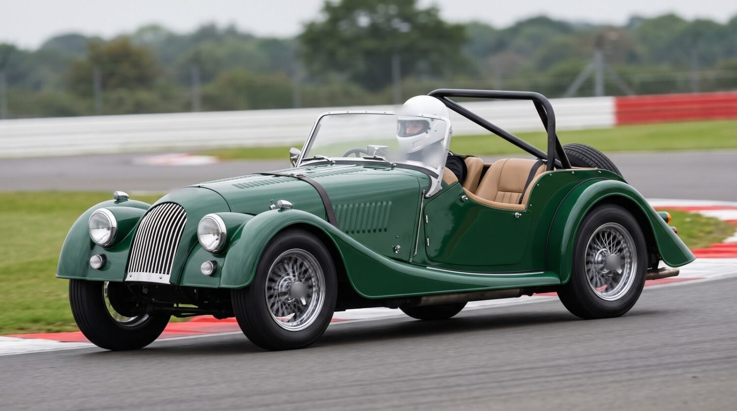 A British Racing Green Morgan 4/4 two seater with a rear roll bar fitted, cornering on a UK race circuit