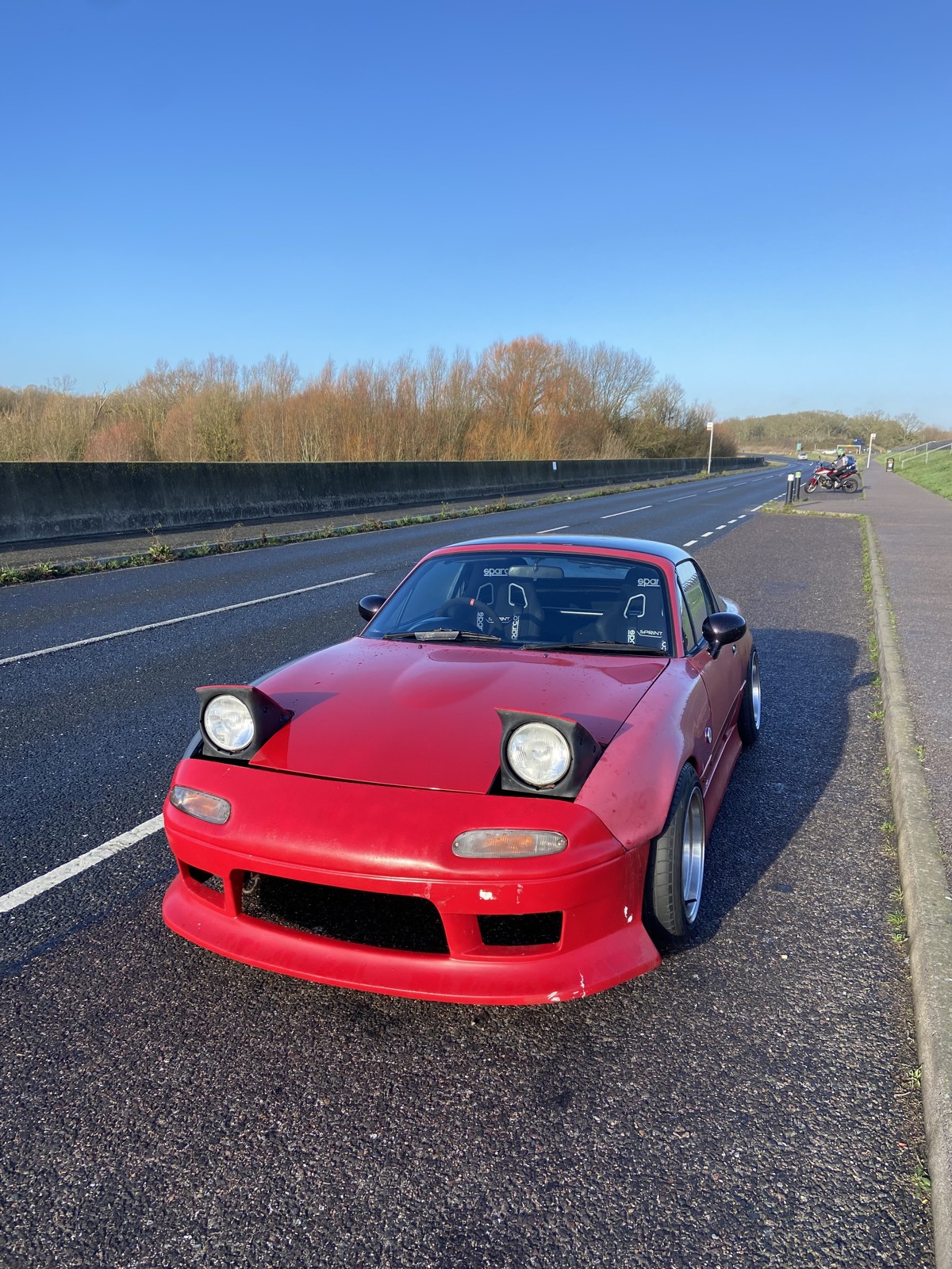 Red Mk1 MX-5 drift car with wide arches and pop up headlights before the rebuild