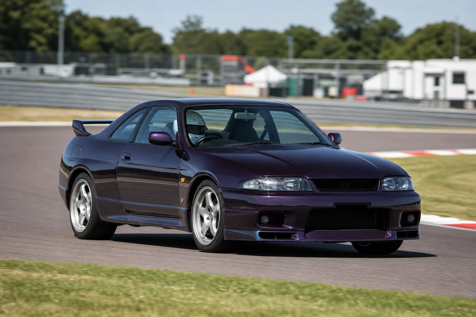 Nissan Skyline R33 on track with a helmeted driver