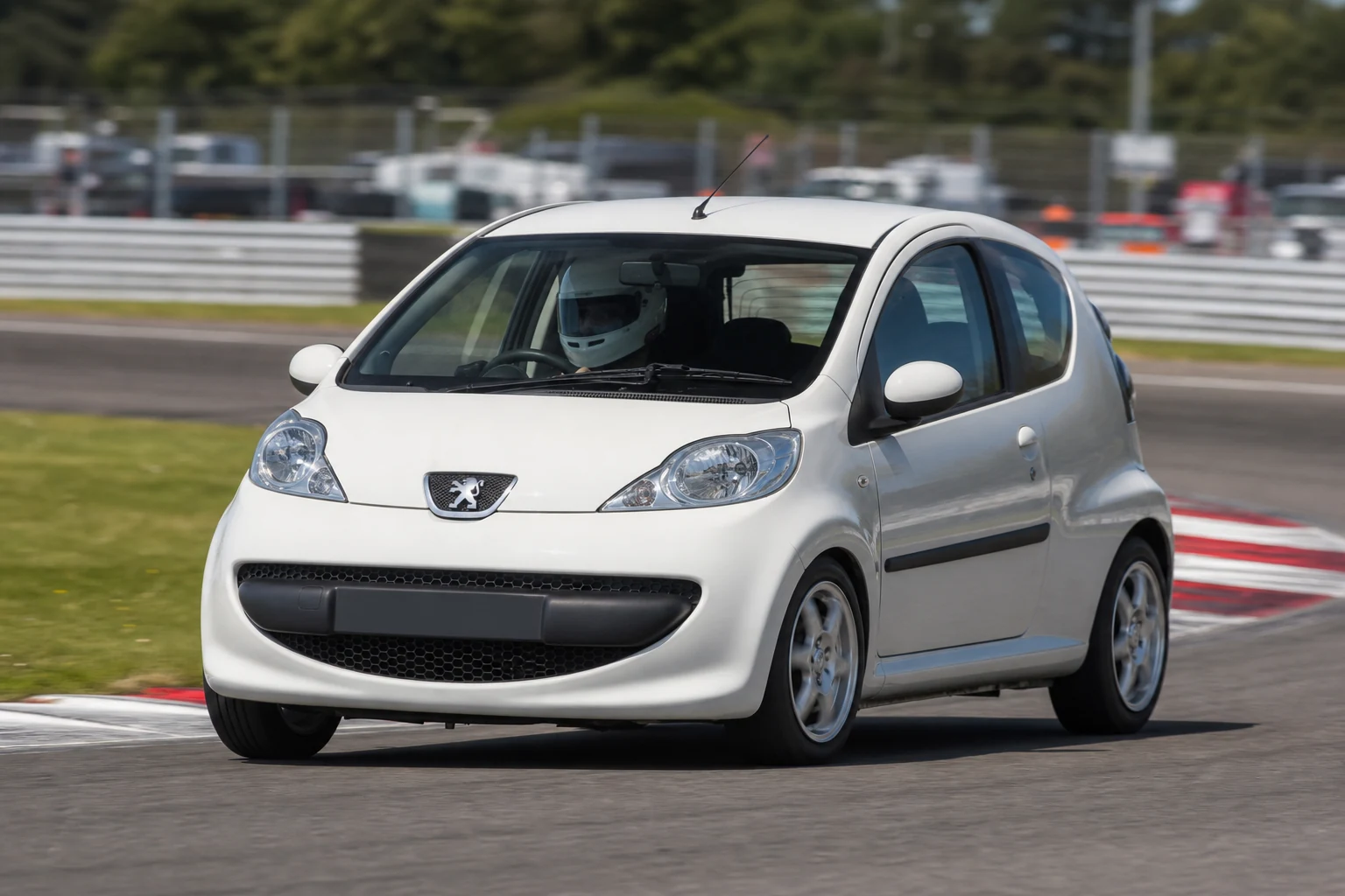 Peugeot 107 on track with a helmeted driver