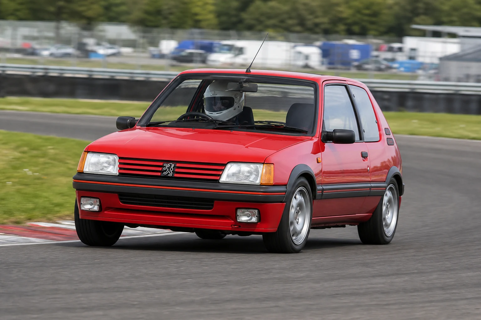 Peugeot 205 on track with a helmeted driver