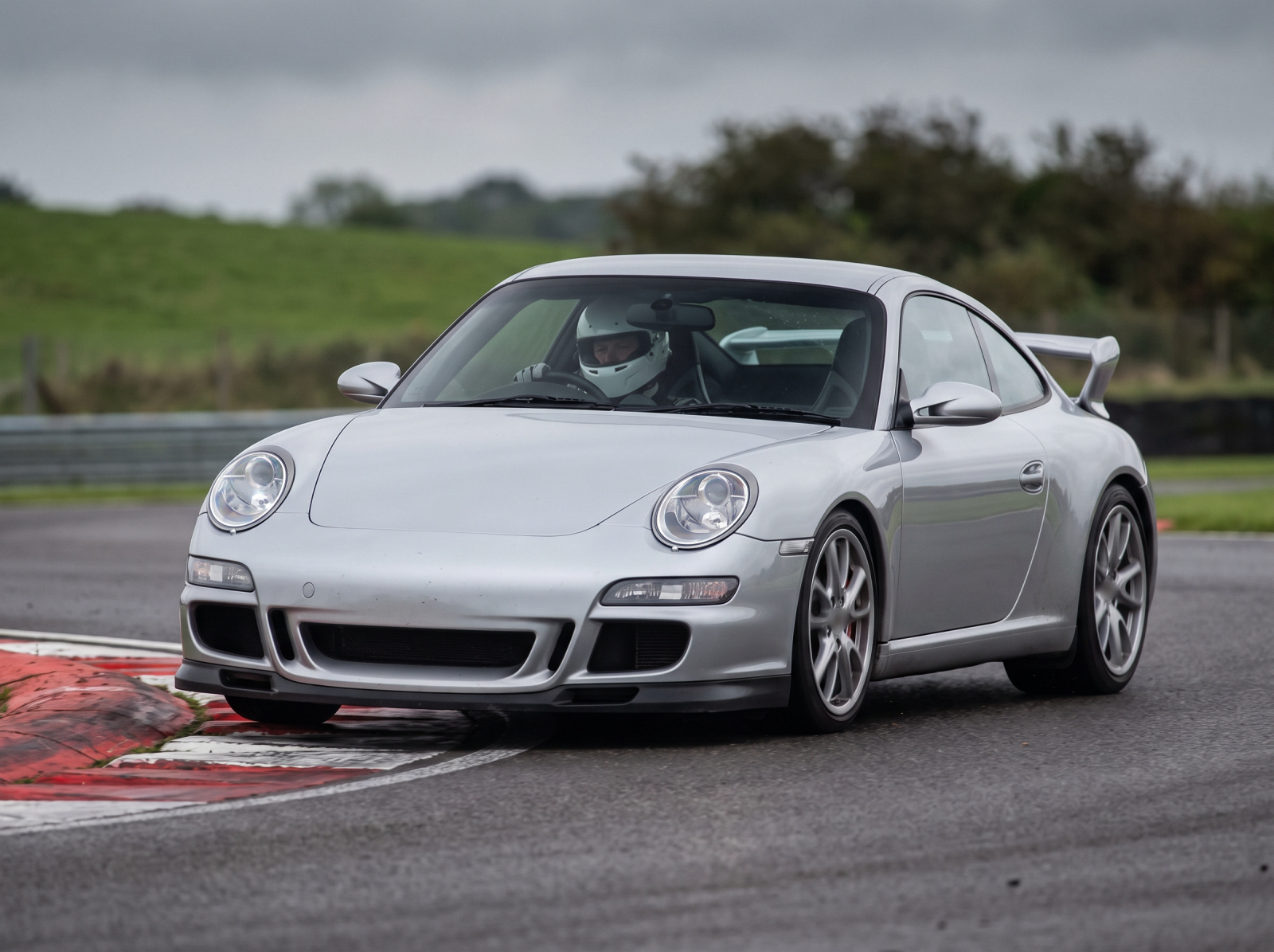 Arctic Silver Porsche 911 997.1 GT3 cornering at an apex on a British race circuit