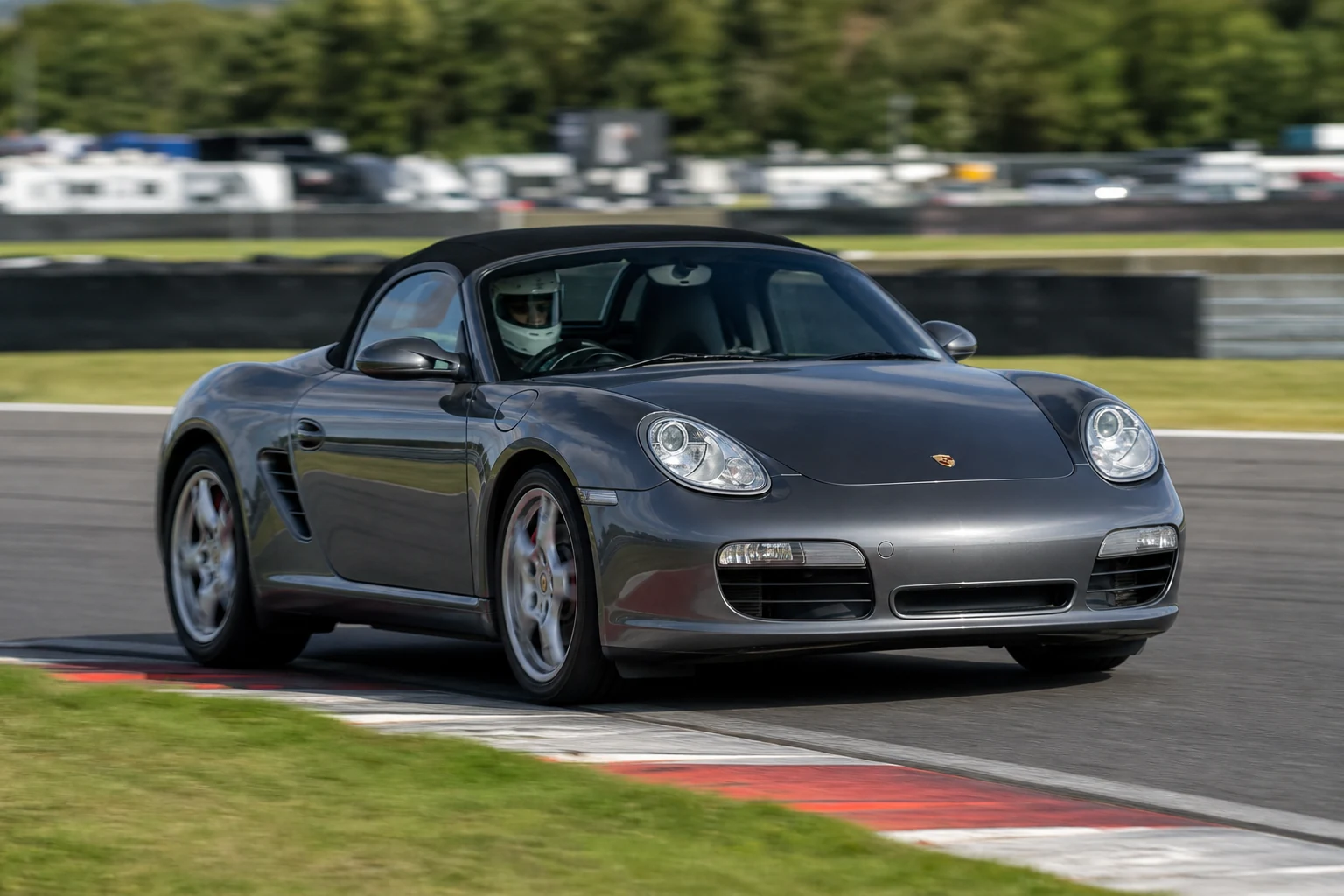 Porsche Boxster 987 on track with a helmeted driver