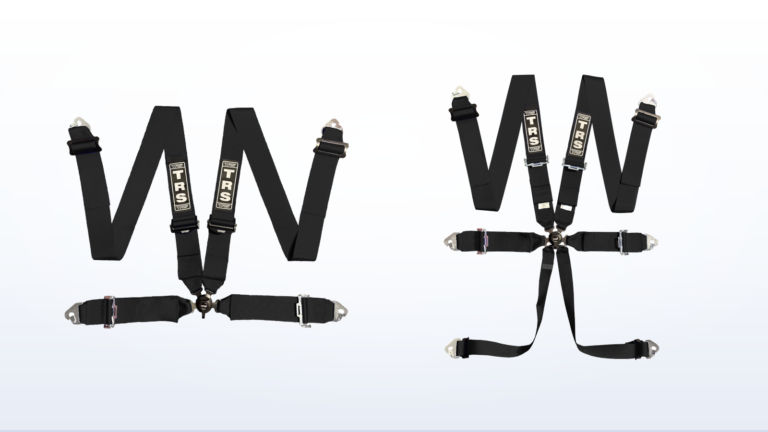 A TRS Magnum four point harness beside a TRS Magnum six point harness, showing the two extra anti-submarine straps that run down from the buckle on the six point