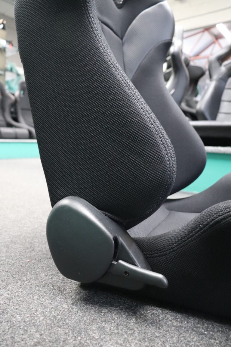 Close up of the quick tilt lever on the side of a Corbeau PSR reclining sports seat in black mesh fabric