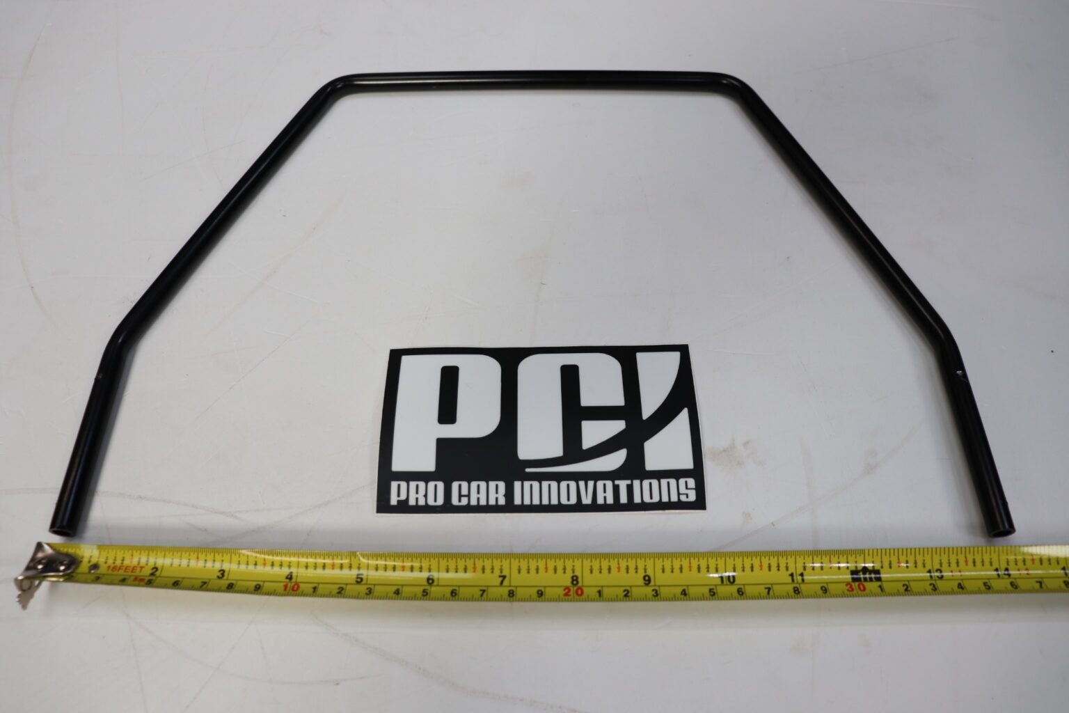 PCI Racing seat slider release handle laid flat with a tape measure beneath it