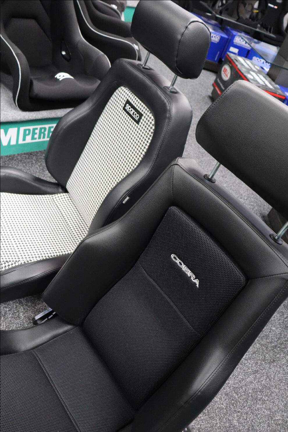 Cobra Le Mans and Sparco GT Houndstooth reclining seats side by side, three quarter view with the Cobra Le Mans in the foreground