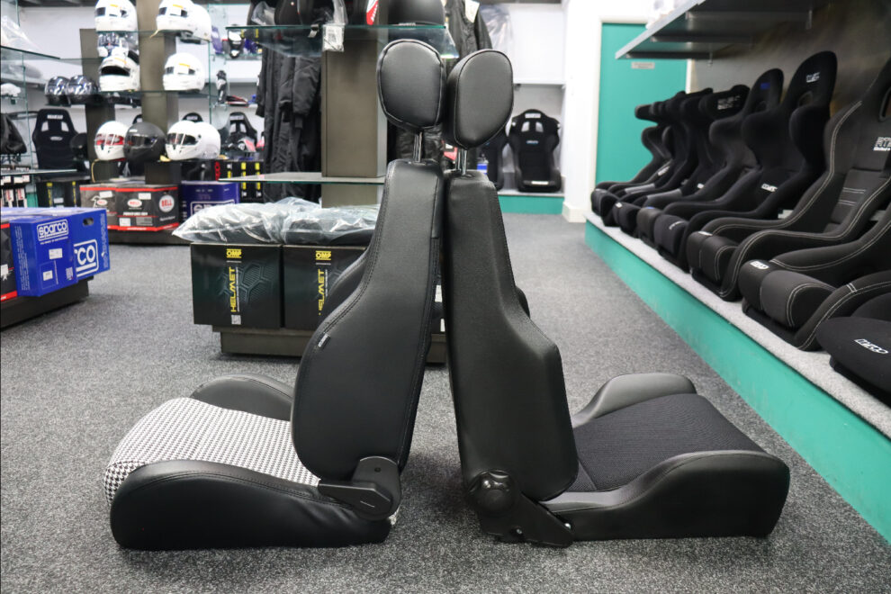 Sparco GT Houndstooth and Cobra Le Mans reclining seats back to back in profile in the GSM Performance showroom, showing backrest height, headrest height and base thickness side by side