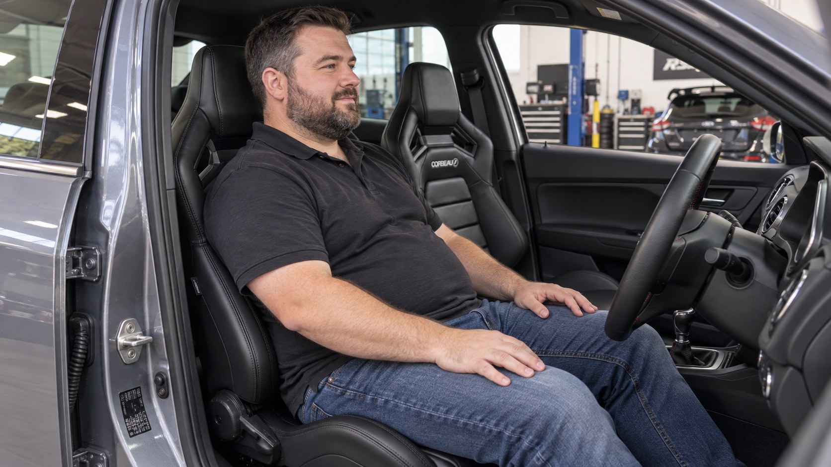 Larger driver seated comfortably in a black Corbeau SVR reclining sport seat installed in a right-hand-drive car