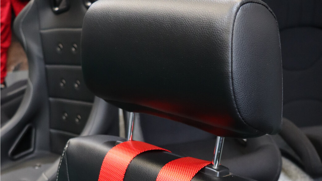 Red Sparco 4 point harness straps passing between the headrest posts of a black Auto Style Type Retro reclining seat