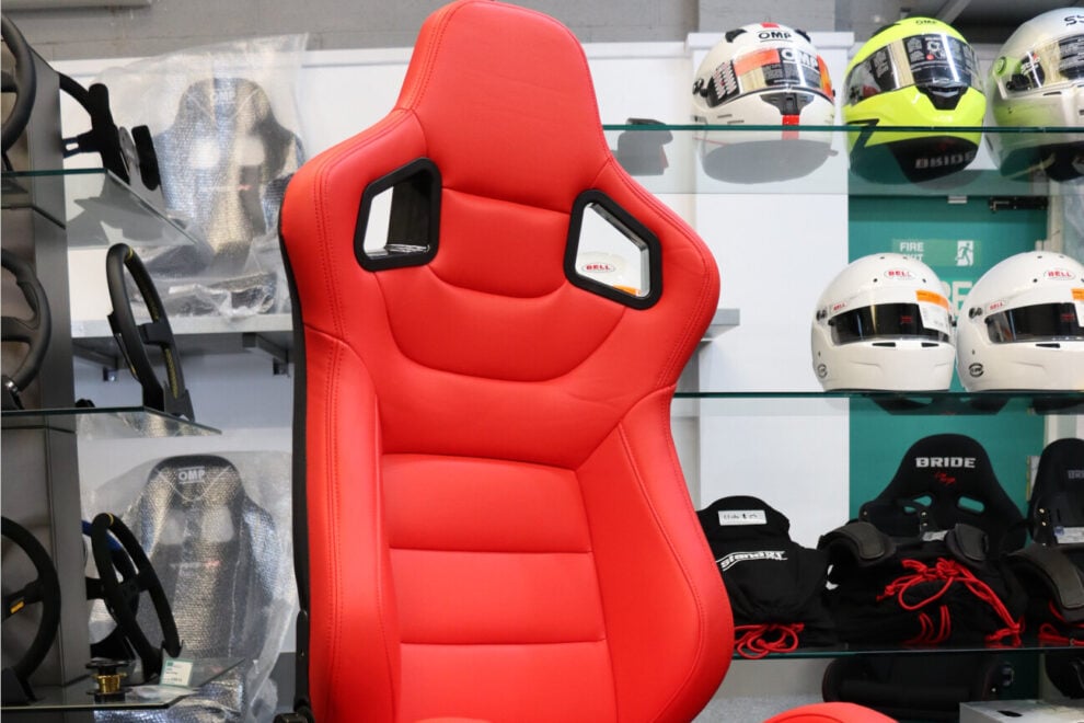 A red Auto Style Type RK reclining seat in front of the helmet display in the GSM Performance showroom