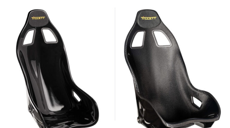 Two identical Tillett B6 bucket seats side by side, the left one in black gloss GRP and the right one in carbon GRP with the woven carbon surface visible