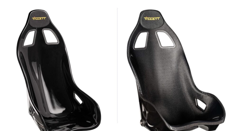 Two identical Tillett B6 bucket seats side by side, the left one in black gloss GRP and the right one in carbon GRP with the woven carbon surface visible
