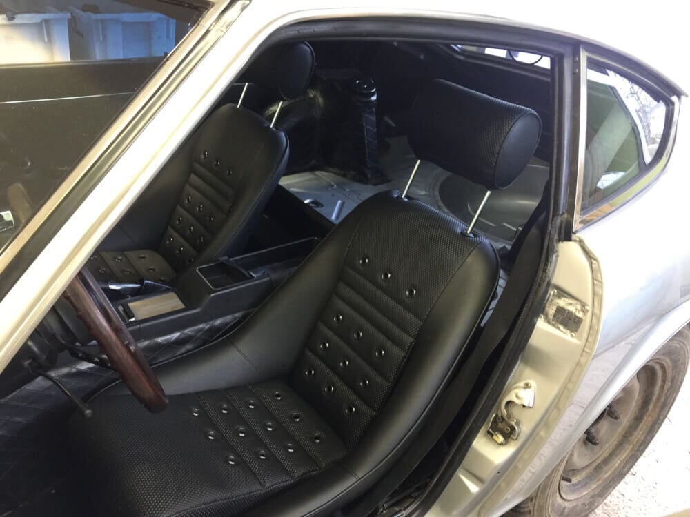Black vinyl classic bucket seats with eyelets and headrests fitted in a silver Datsun Z