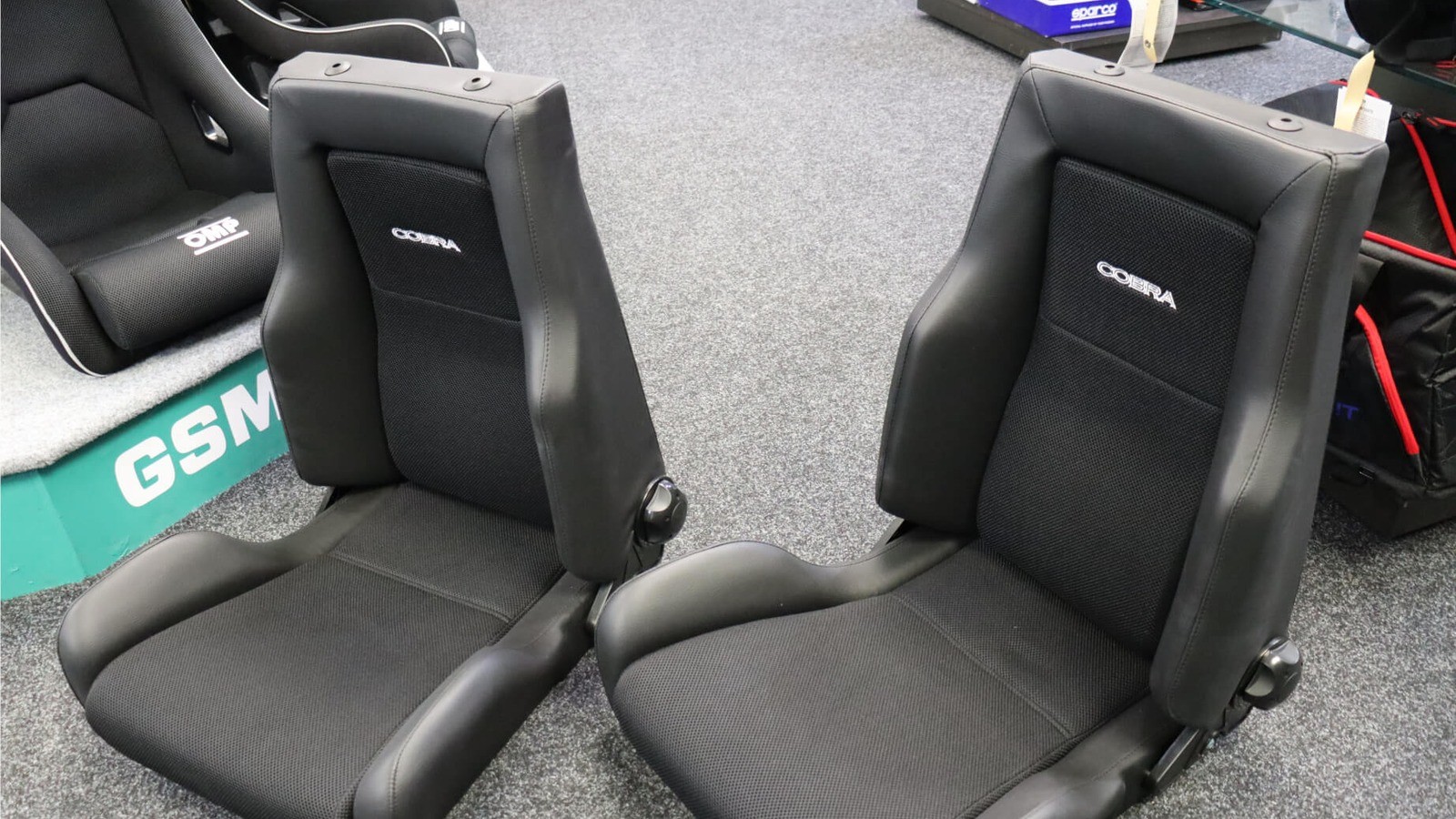 Pair of black Cobra Le Mans Land Rover Defender reclining seats on the showroom floor, vinyl outers with spacer fabric centres