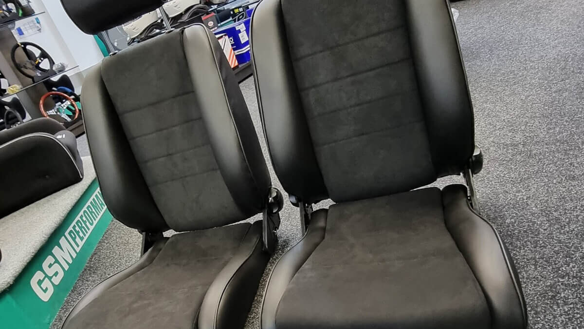A pair of Cobra Stuttgart reclining seats with suede centres and black outers in the GSM Performance showroom