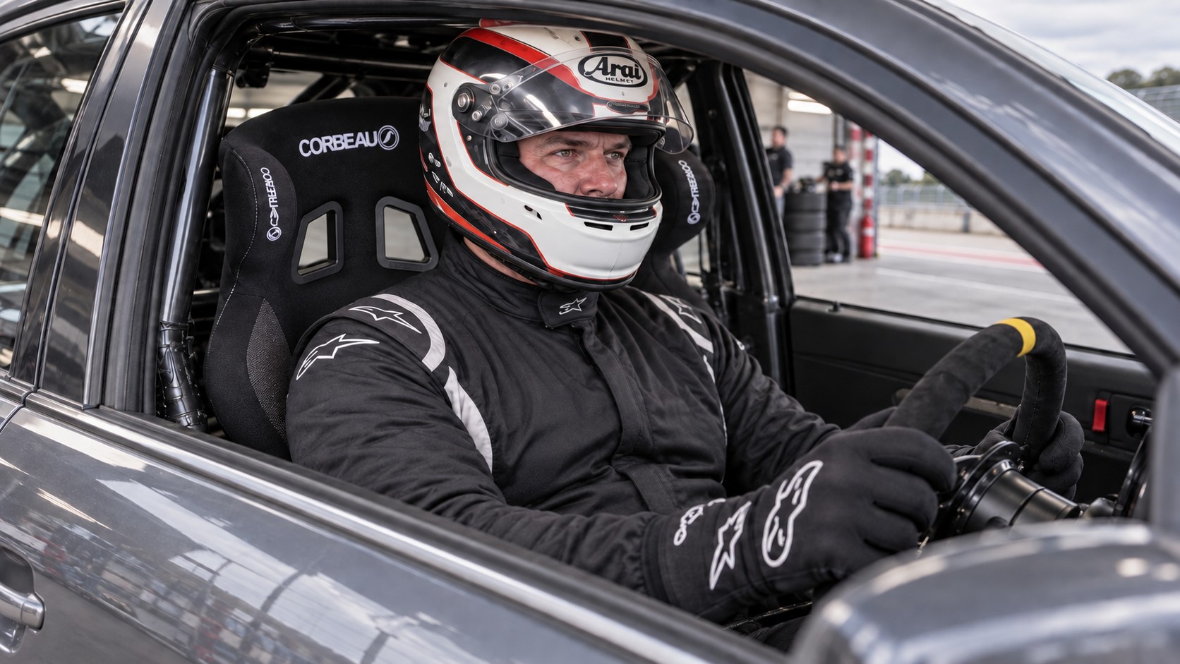 Broad-built helmeted driver checking the fit of a Corbeau Revenge X XL motorsport seat
