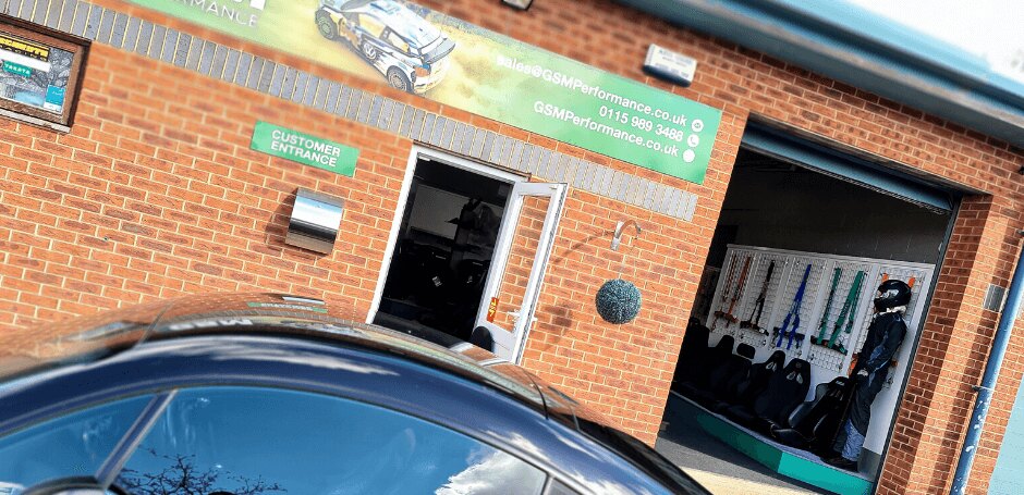 The GSM Performance showroom entrance with harnesses and bucket seats visible through the open roller door