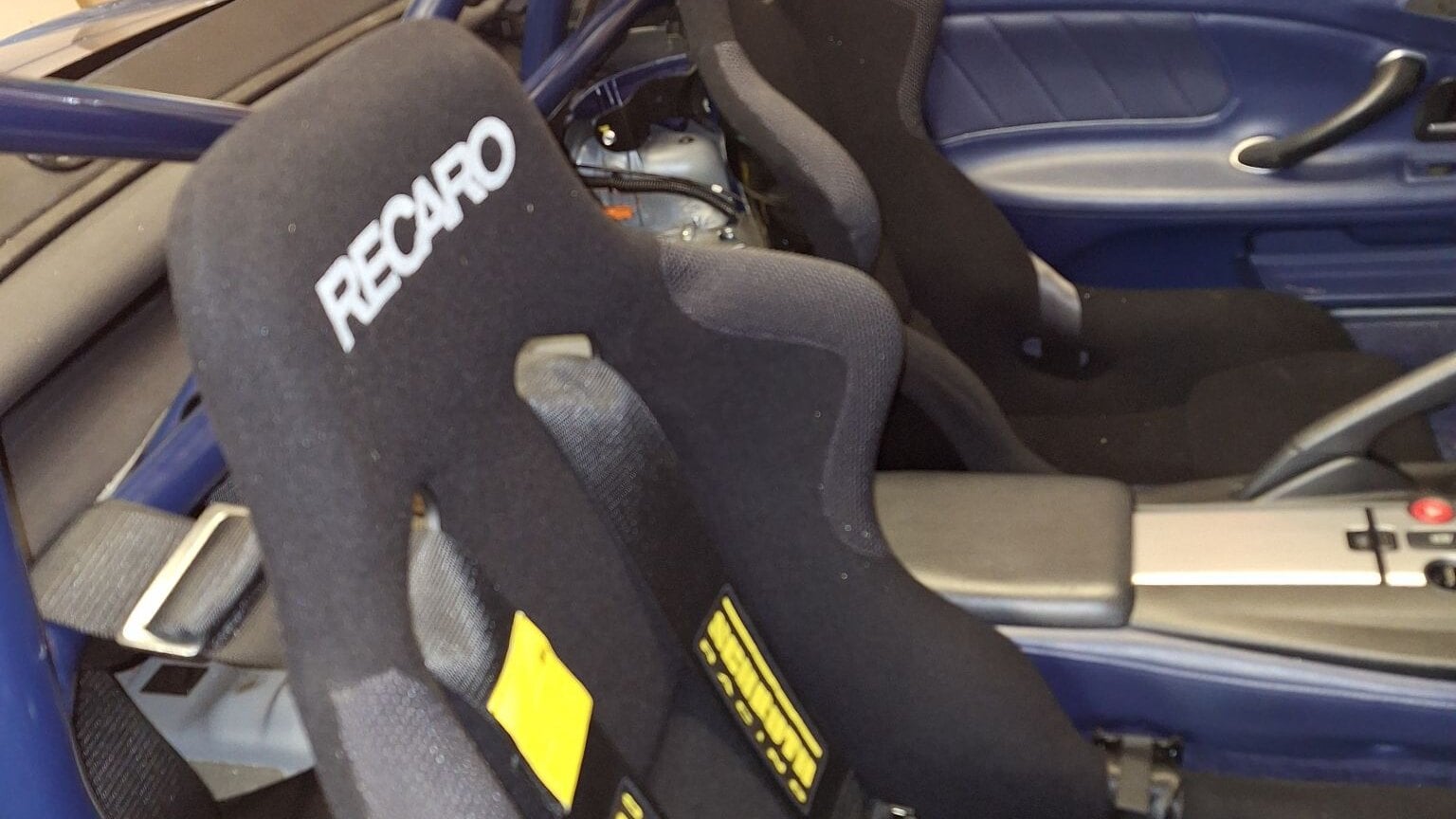 Black Recaro Profi SPG bucket seats with Schroth harnesses in a Honda S2000 with a blue roll cage and blue door trims