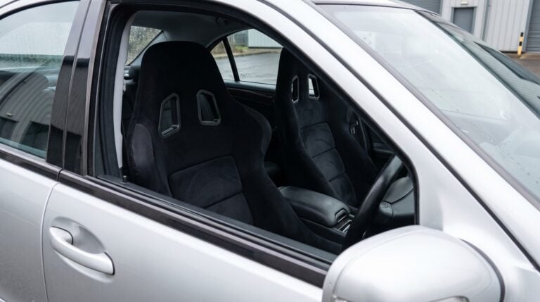 Pair of black Sabelt GT3 FIA bucket seats fitted in a silver Mercedes-Benz C32 AMG W203 saloon, seen through the open driver door window