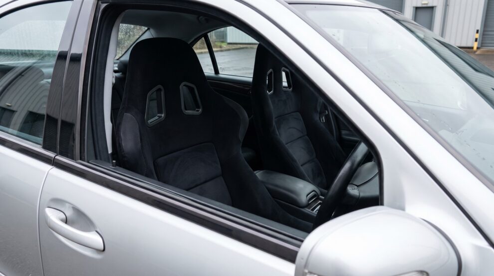 Pair of black Sabelt GT3 FIA bucket seats fitted in a silver Mercedes-Benz C32 AMG W203 saloon, seen through the open driver door window