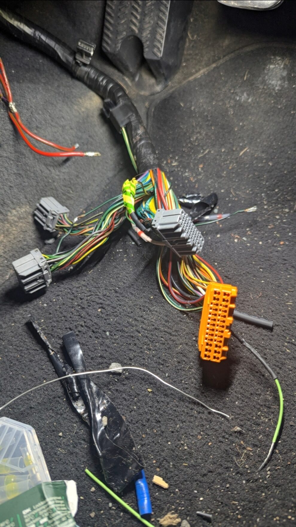A cut and spliced body control unit wiring loom from the MG ZS laid out on the ground with its connectors