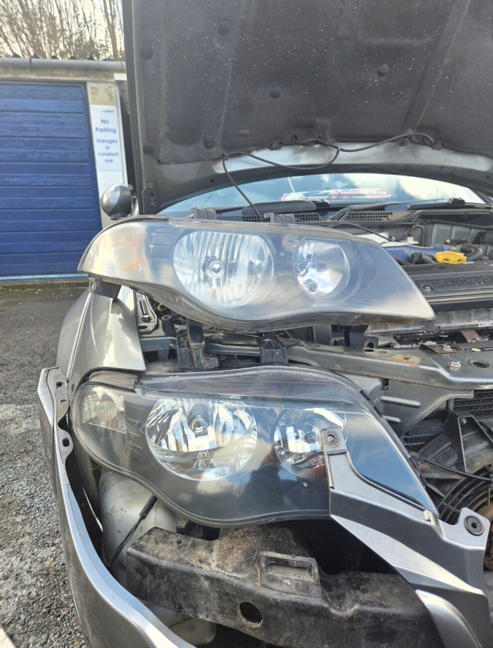 A yellowed original MG ZS headlight unit next to a clear replacement unit for comparison