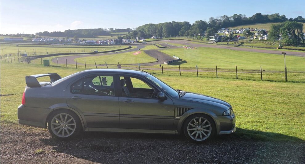 The MG ZS parked at the Lydden Hill circuit during the Legends festival with the track visible behind