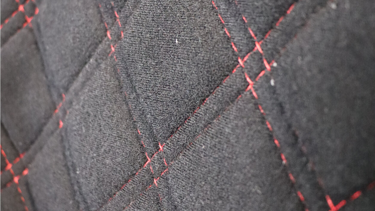 Close-up of red diamond stitching on the black velour back of a Mirco bucket seat